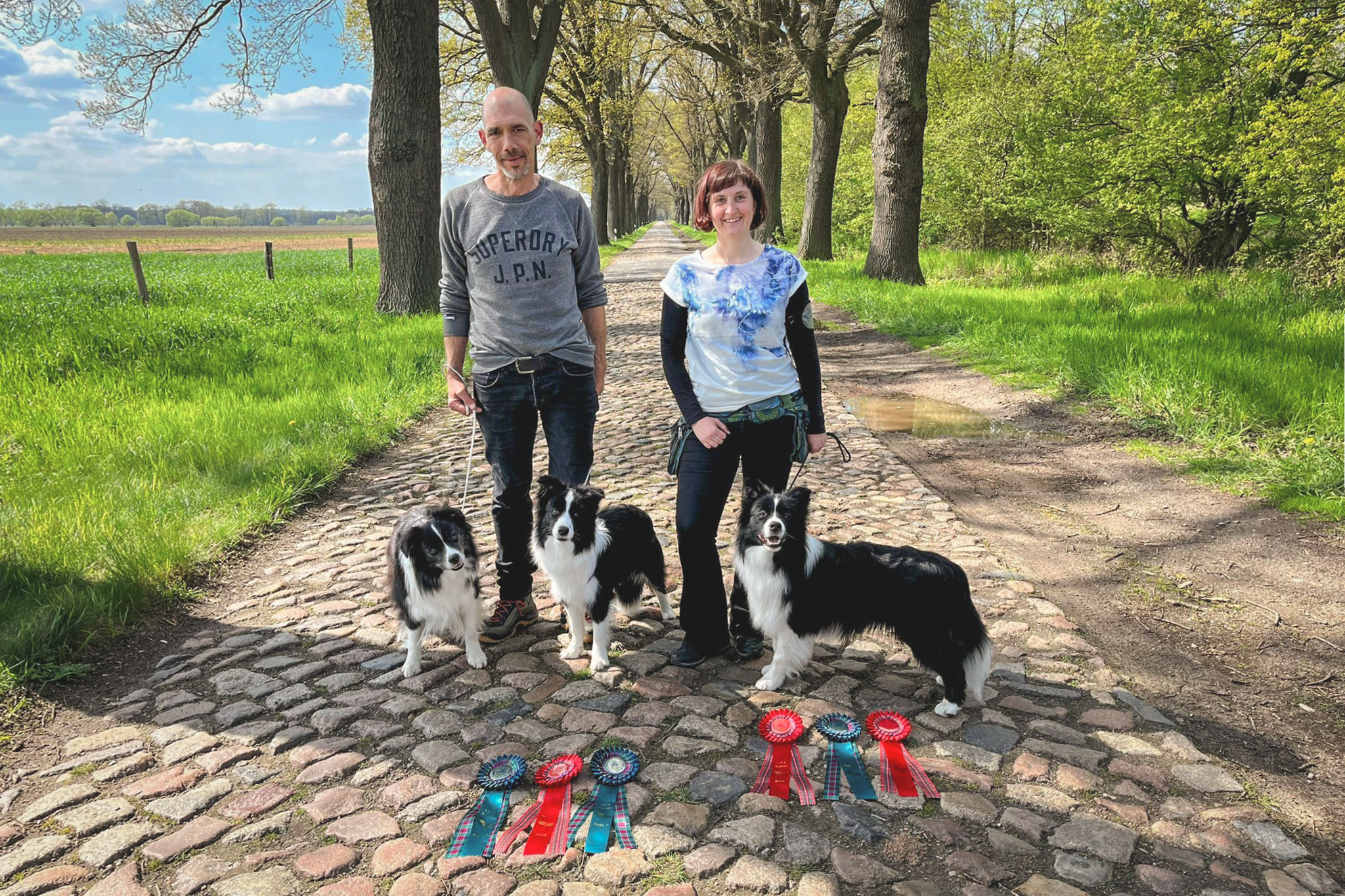 Zwei Menschen mit drei Border Collies