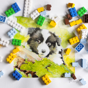 Aquarellierte Bleistiftzeichnung eines Border Collie Welpen zwischen Legosteinen
